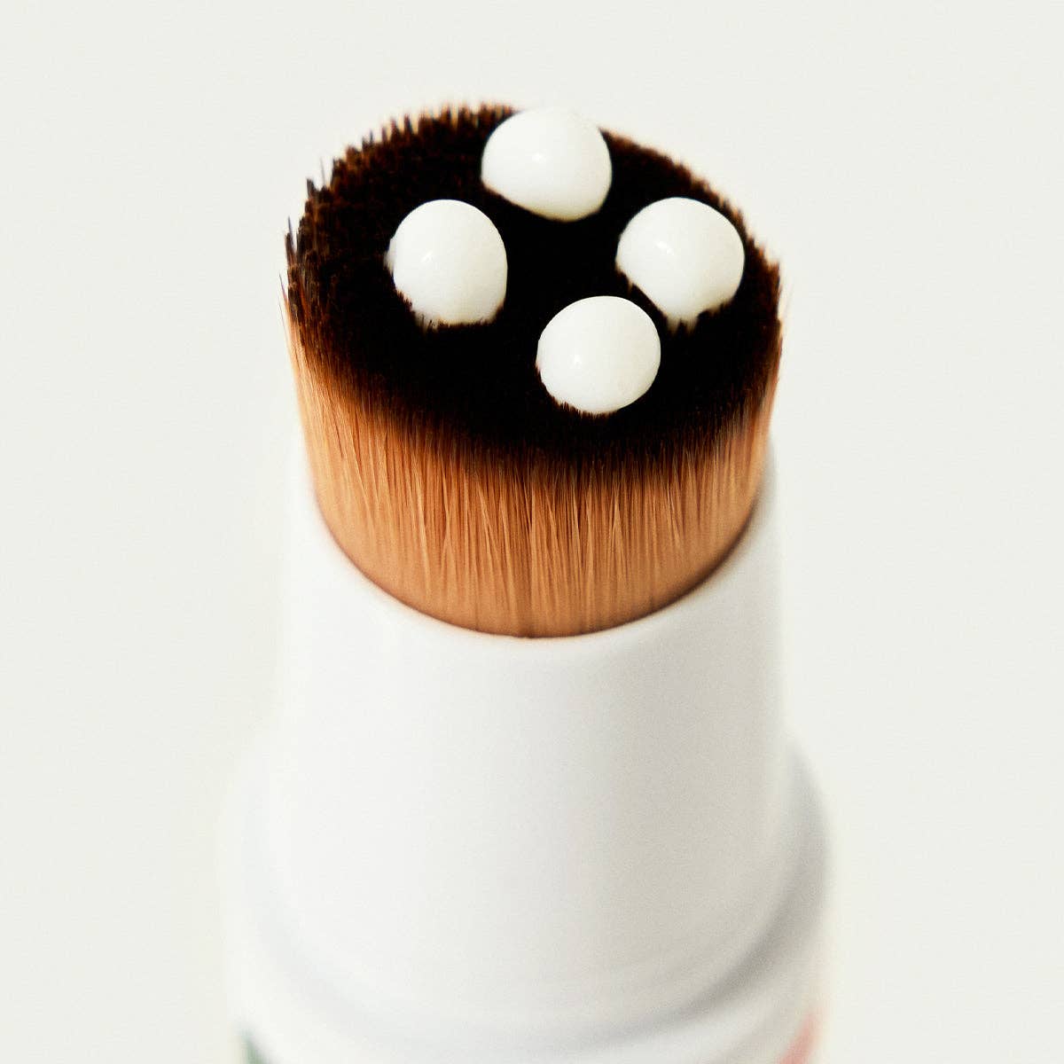 Close-up of the Soft Paws brush applicator dispensing hydrating lotion
